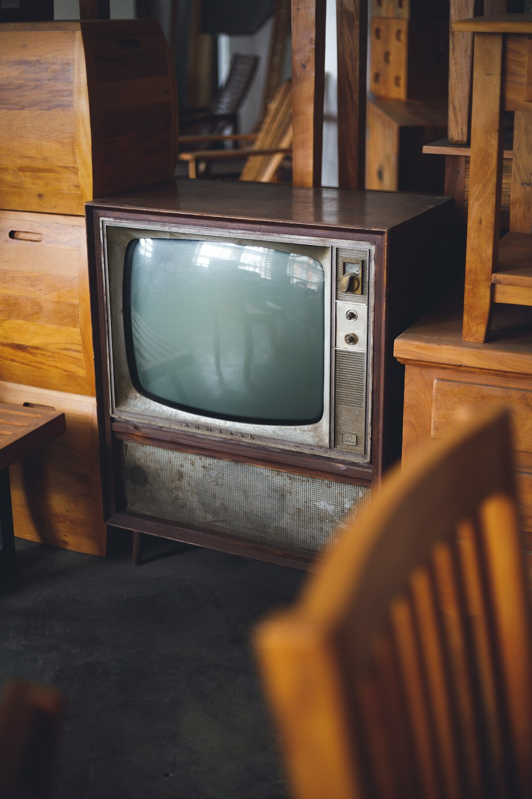 Altes Röhrenfernsehgerät zeigt einen bunten Werbespot in einem Wohnzimmer der 1980er-Jahre